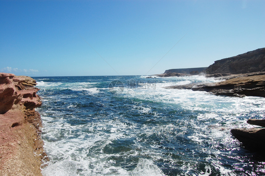 海岸的岩石海洋支撑蓝天红色蓝色悬崖波浪石头海浪图片