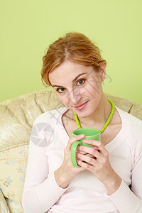 茶绿色项链喝茶的女人绿色女性杯子健康项链饮料享受咖啡成人闲暇背景