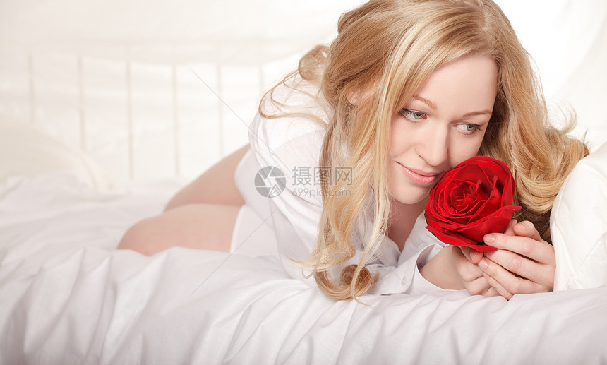 与玫瑰睡床上的女孩成人身体思考微笑女士枕头女性金发情人女郎图片