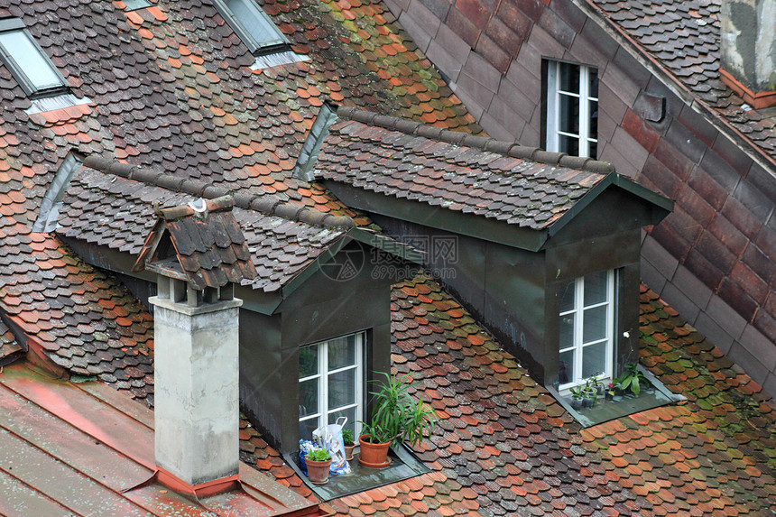 中世纪城市房子屋顶的瓷砖制品红色烟道天空绿色阁楼陶瓷建筑窗户草地图片