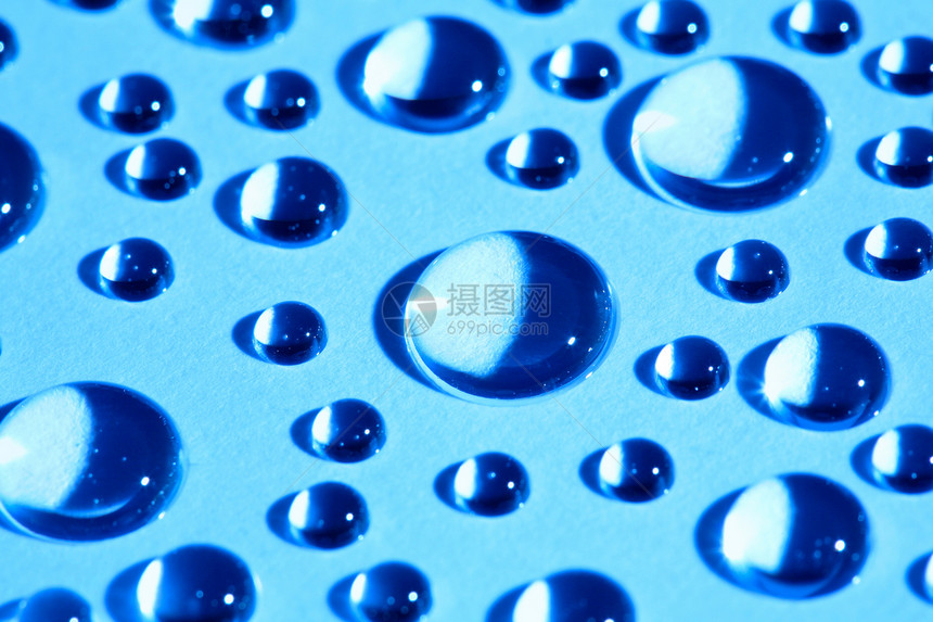 蓝色玻璃上的水滴宏观反射圆圈图片