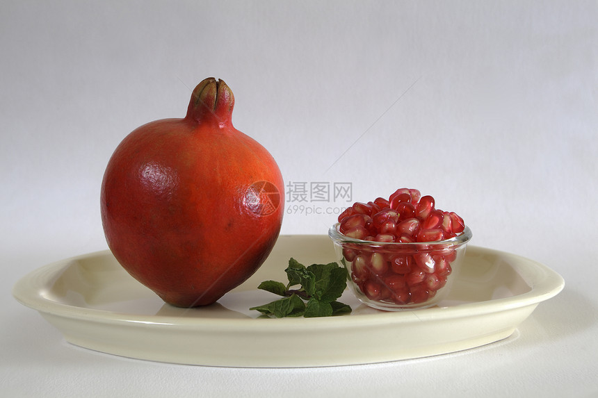 石榴水果和种子白色圆形热带盘子营养食物小吃红色图片