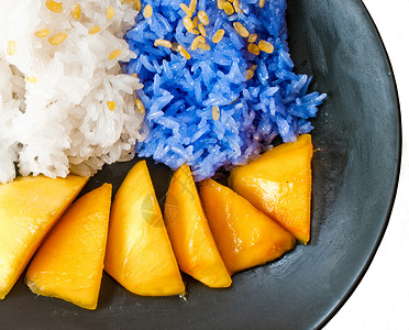 芒果夹心椰子糕粘硬的米饭芒果泰国甜点牙齿食物椰子美食热带早餐竹子食品紫色牛奶背景