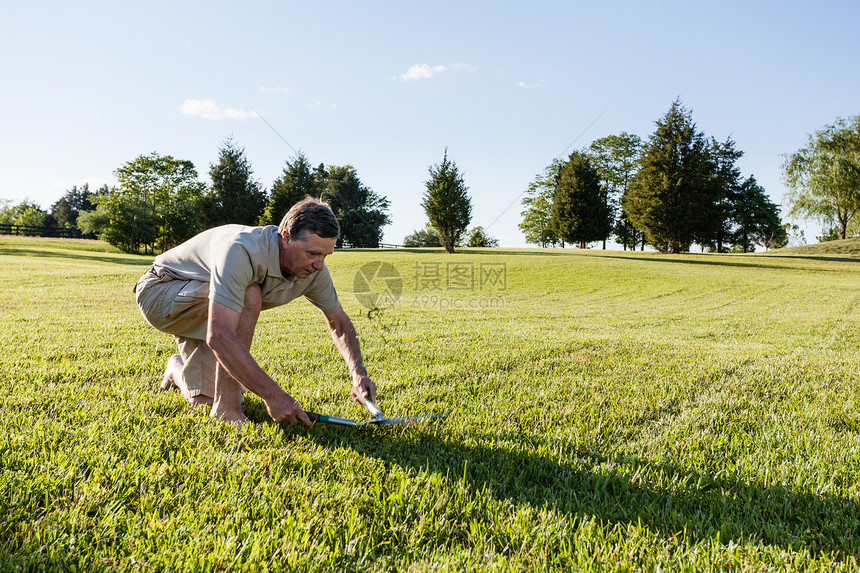 高级男子用剪刀割草剪切景观弹力弹性挑战性园艺成功草皮男性园丁图片