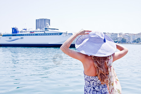 穿洋船背景的姑娘裙子女性假期乘客头发旅行帽子天空闲暇活动背景图片