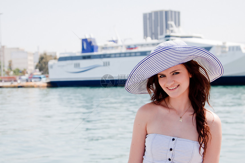 穿洋船背景的姑娘假期天空女性成人头发气候冒充乘客帽子海岸线图片