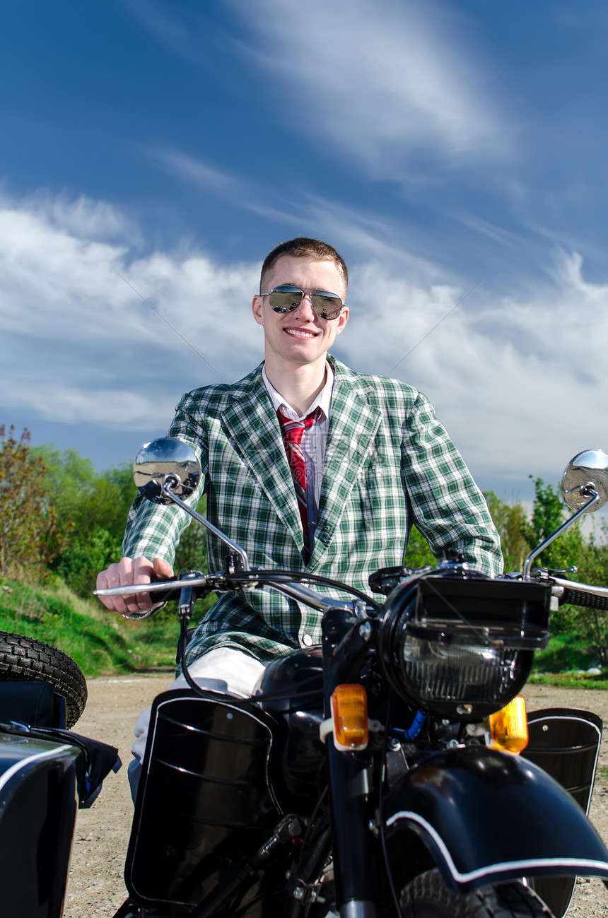 骑摩托车和随车的经典人自行车文化旅行男性航程天空假期手提箱眼镜微笑图片