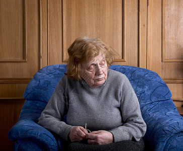 老妇人坐在扶手椅上宠物退休女士中风医学老年奶奶房子扶手椅祖母背景
