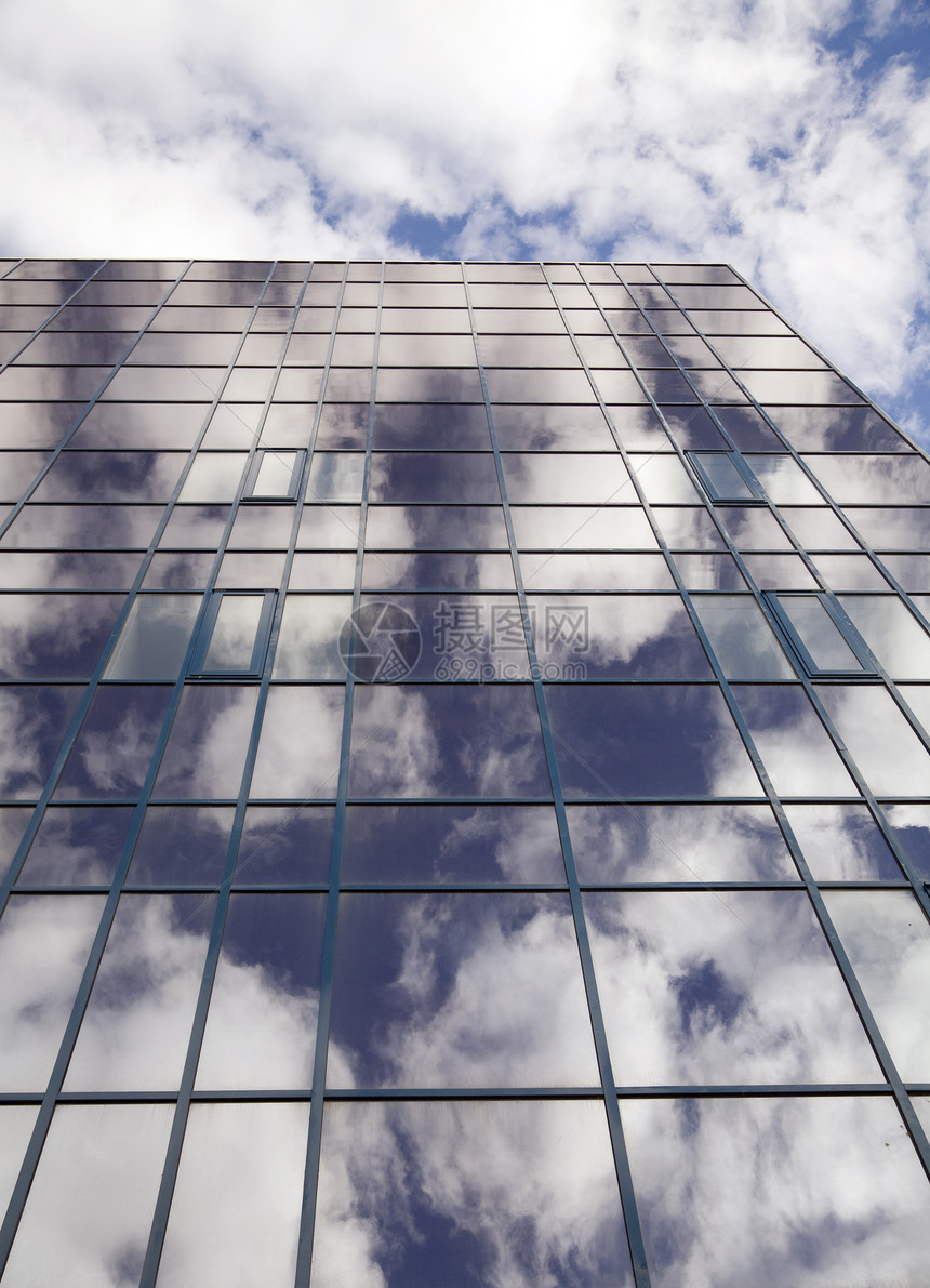 带有背景云层上反射的摩天大楼窗口城市金属建筑物建筑学生活玻璃天际蓝色工作总部图片