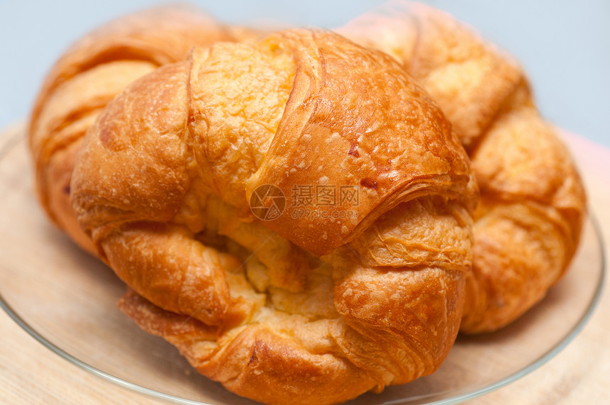 木板上新鲜烘烤的法国牛角面包新月黄油糕点面包美食早餐面团盘子脆皮甜点图片