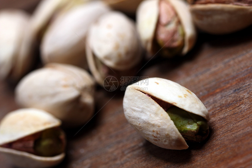 Pistachios 螺旋藻棕色坚果核心营养盐渍小吃树叶绿色木头团体图片