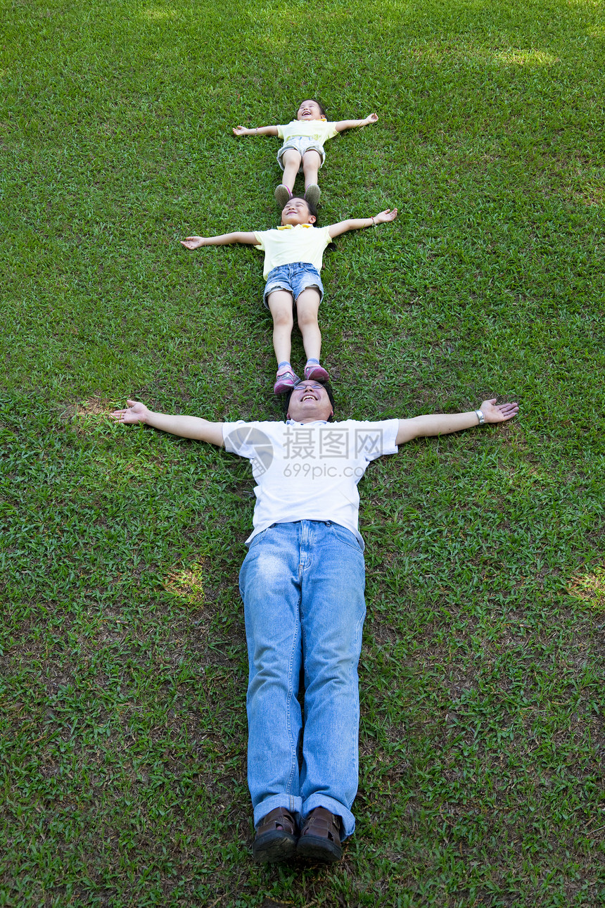 躺在草地上的幸福的家庭女孩说谎闲暇父亲儿子们女士自由爸爸场地女性图片