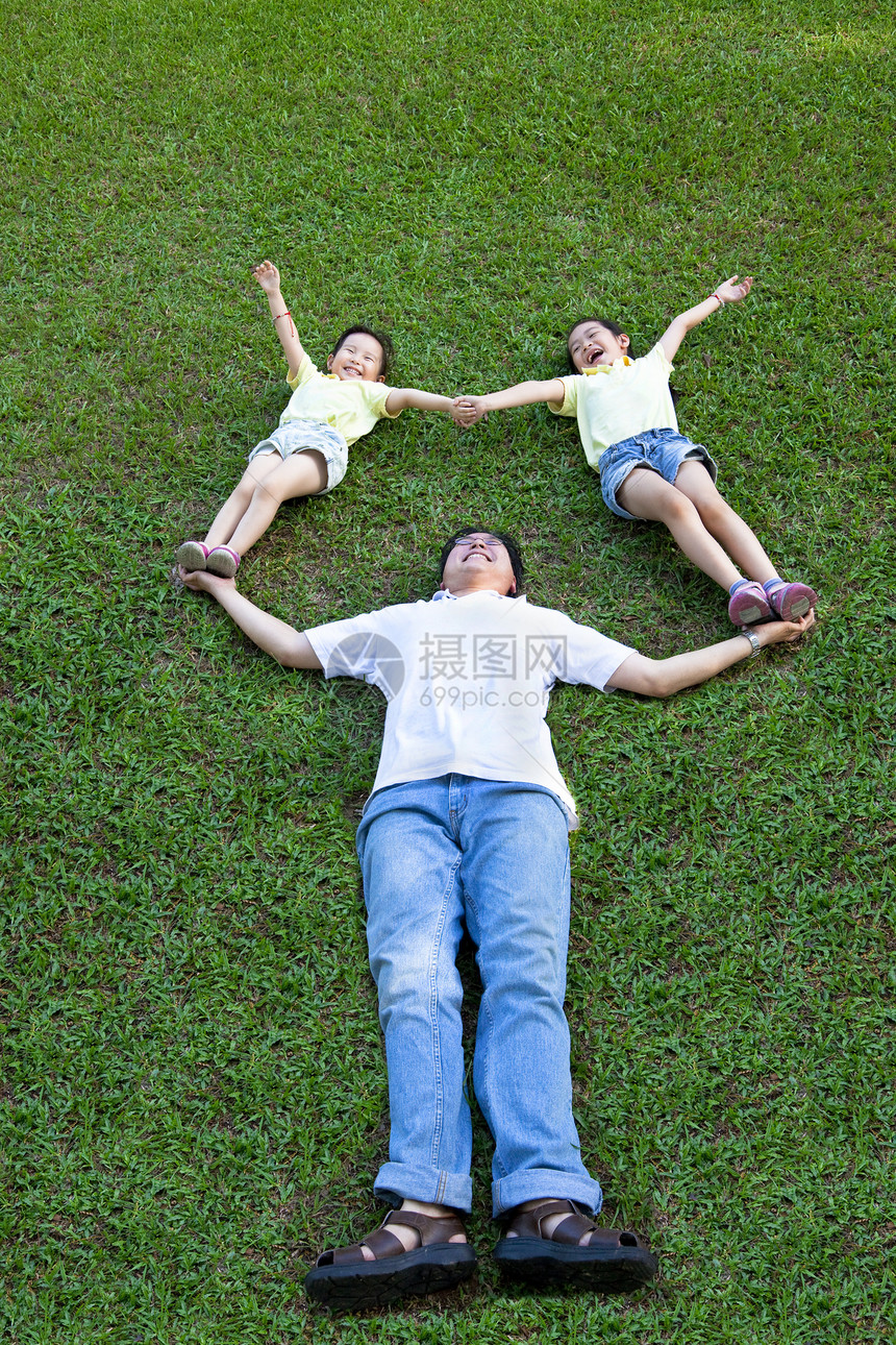 欢乐的亚洲家庭在草地上躺着玩耍图片