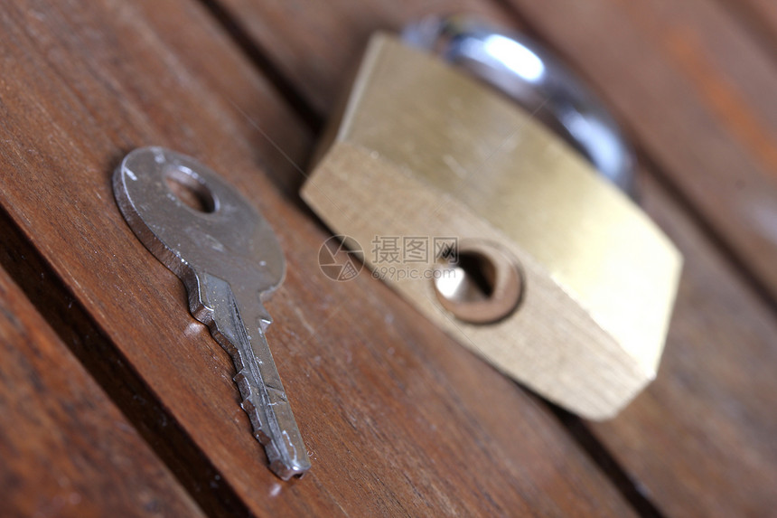 木木背景上带有密钥的锁锁金属挂锁钥匙木头图片
