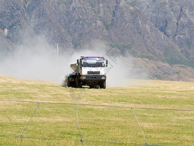 在牧场草原上撒肥的卡车旋转化学品场地吊具喷涂草地喷雾器生长农田治疗背景