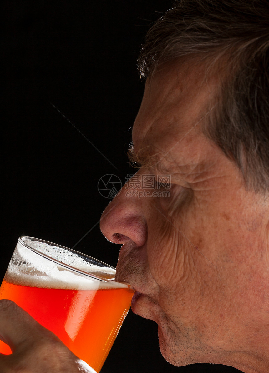 高级男子吸喝品脱玻璃啤酒背景黑色琥珀色酿造男性饮料玻璃手臂背光工作室图片