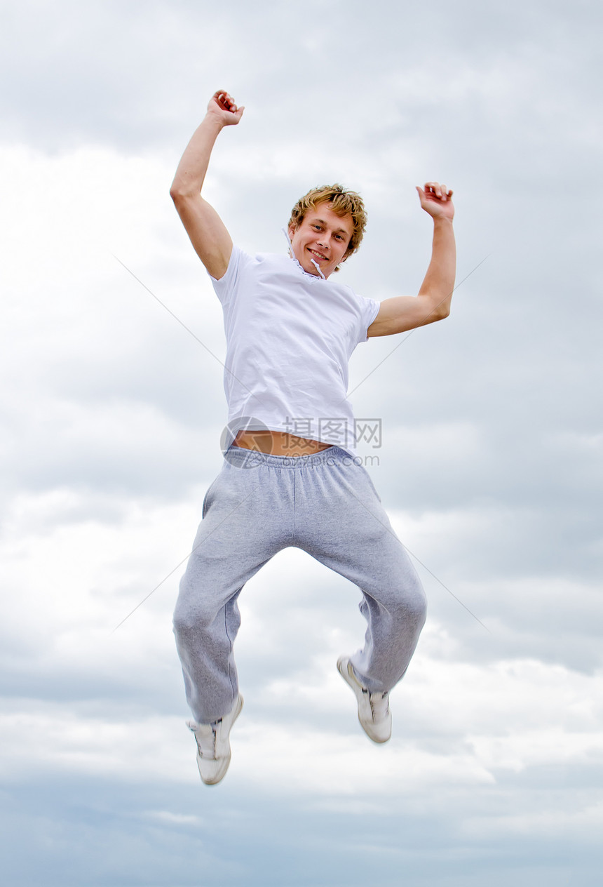 一个快乐的年轻人在空中对天跳跃的肖像享受天空运动自由男性精力乐趣图片