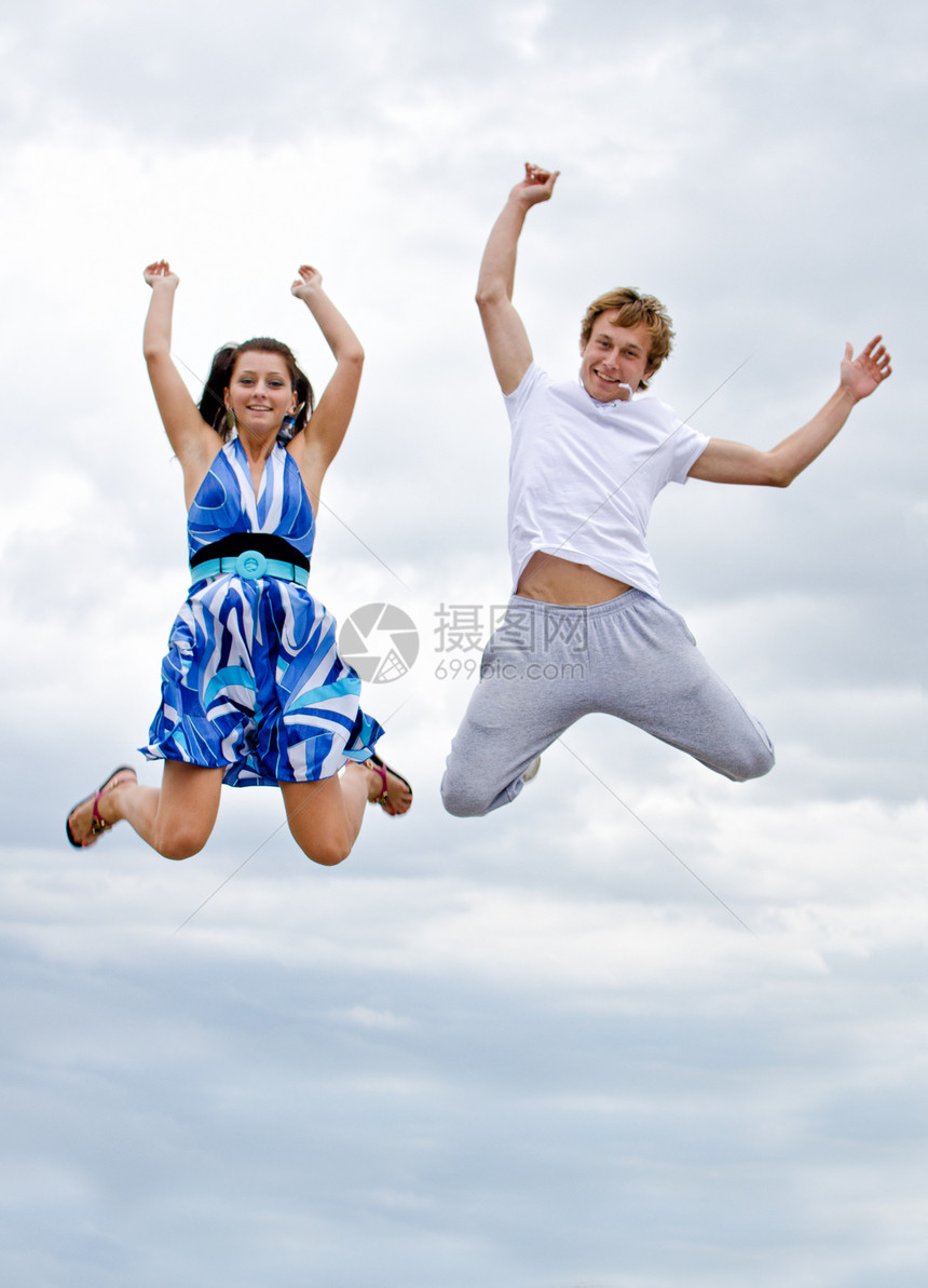 一对快乐的年轻夫妇在天空中跳跃的肖像女士自由女性享受运动乐趣活力喜悦女孩男性图片