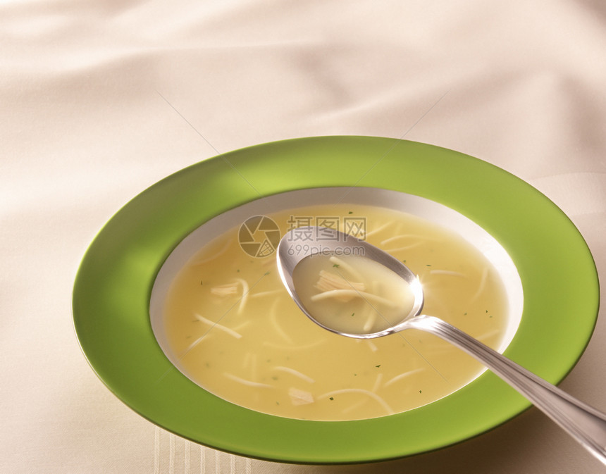 在绿色盘子上加热鸡汤食物食品素食课程咸味草药勺子餐厅桌子图片
