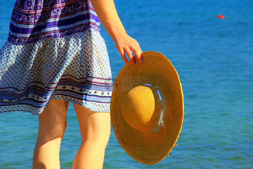 她的帽子假期闲暇微笑季节蓝色海滨女士游客海洋女孩图片