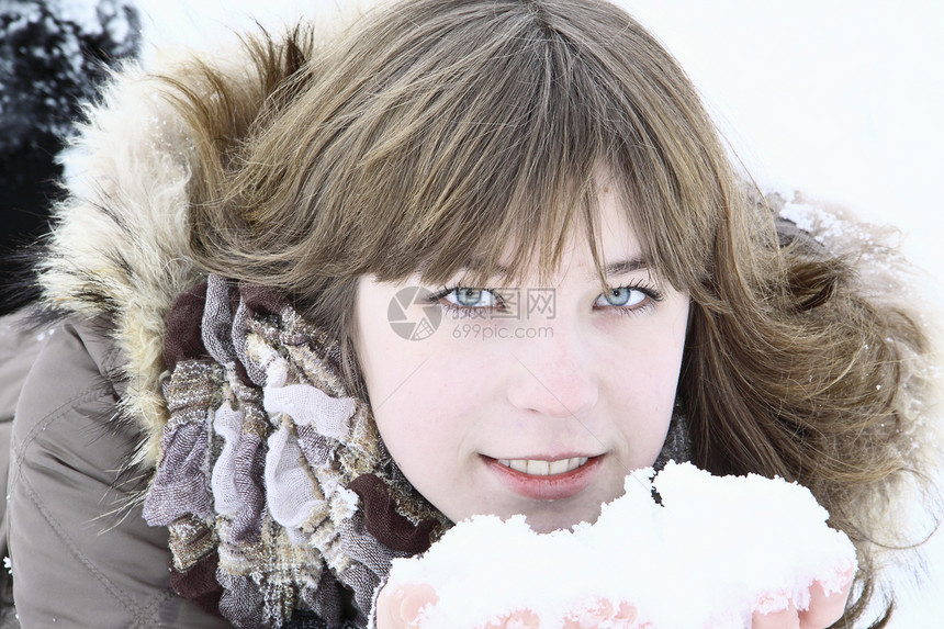 美丽的女孩下着雪在手头发金发夹克雪地白色褐色棕色灰色微笑眼睛图片