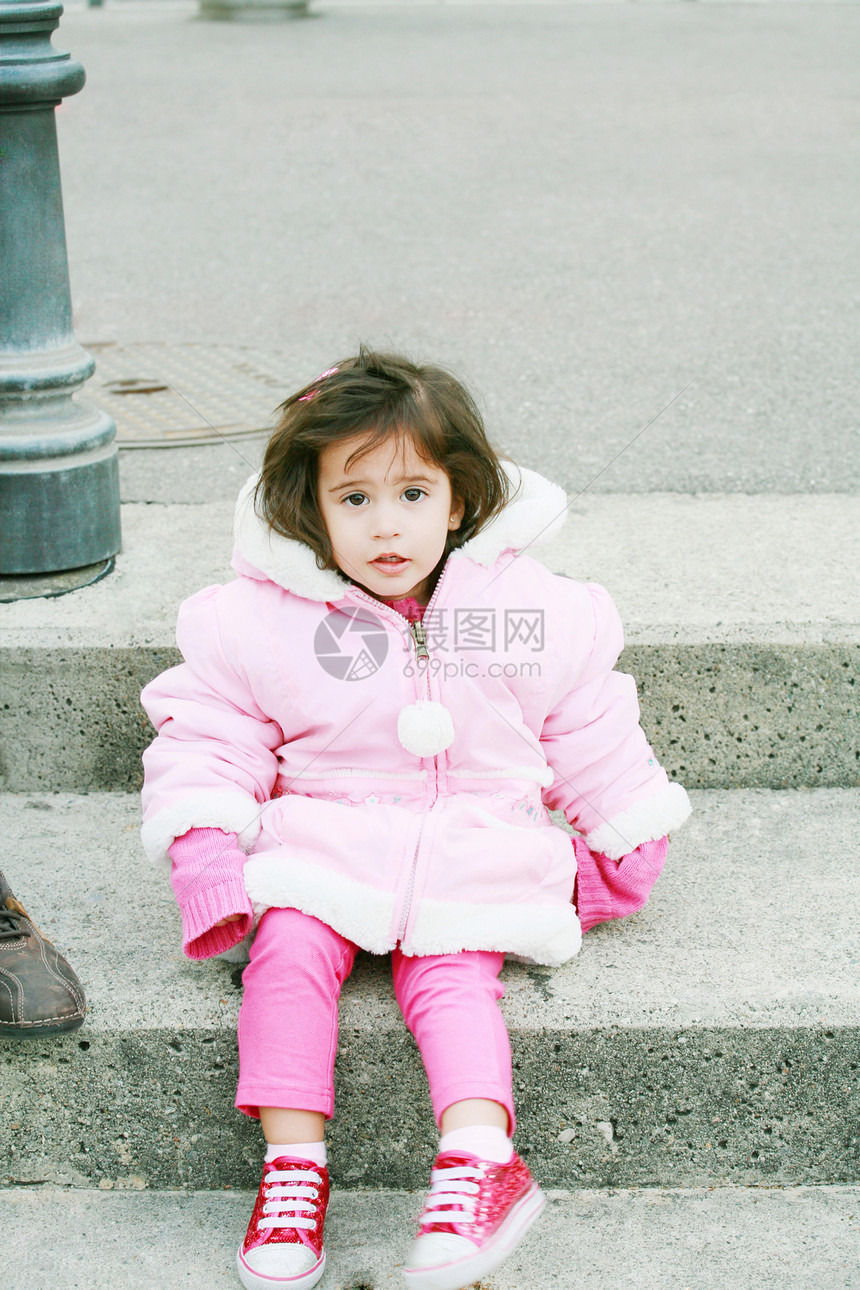 穿着冬衣的小女孩坐在楼梯上看着c(C)图片