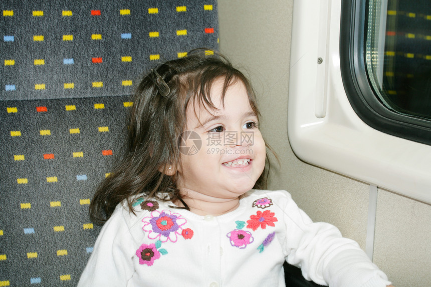 可爱的小女孩在一辆移动的列车上看着窗子图片