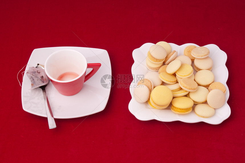 空茶杯和天鹅绒平板上混合的马卡龙盘图片
