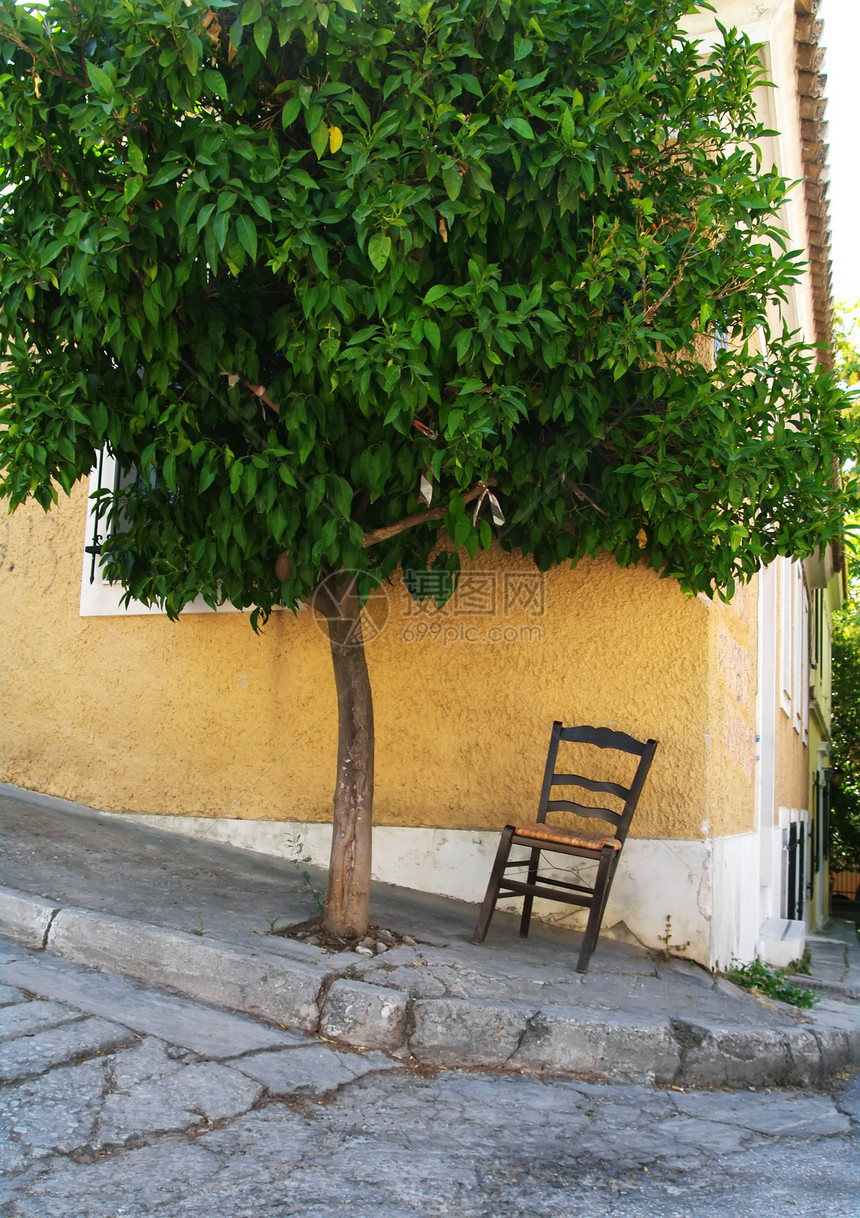 独自坐在雅典中部一棵树下的孤单椅子下图片