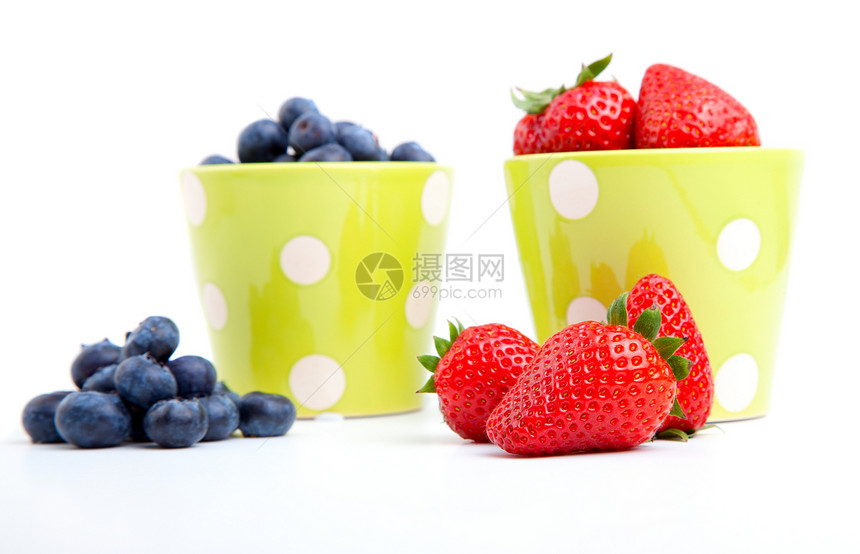 将新鲜果子放在一个绿色的杯子上 在白色的背面浆果黑色甜点小吃食物蓝色水果活力红色图片