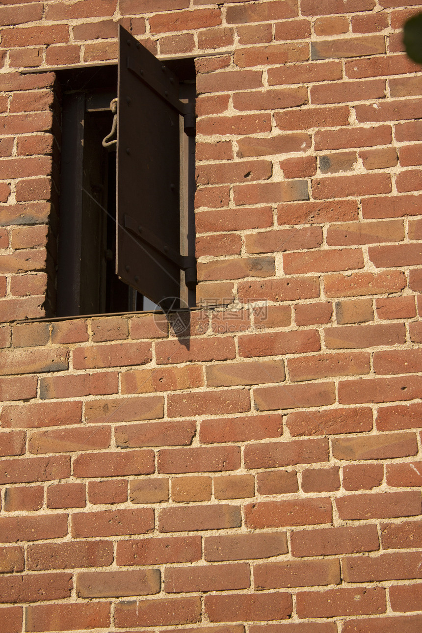 砖墙上一个老生锈的窗户建筑风光结构画幅水泥力量红色都市纹理监狱图片