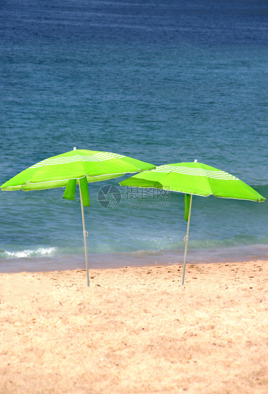海滩上两个绿色的太阳雨伞图片