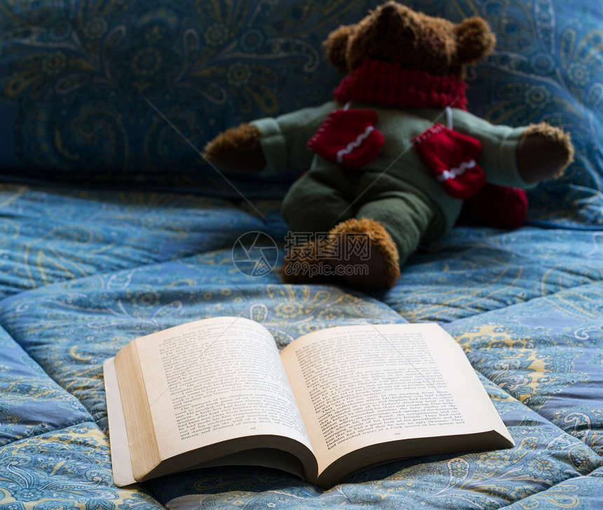 用泰迪熊在床上打开纸本闲暇文学手套玩具蓝色聚光灯平装风格玩具熊装饰图片