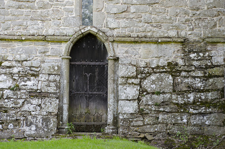 埃拉门塔一座旧的14世纪教堂的石墙上的老木门背景