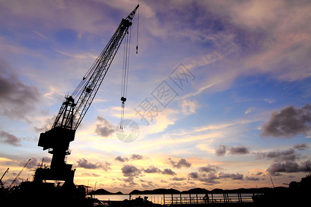 日落时码头的起重车起重机船厂船尾螺旋桨橙子进口后勤运输天空货运背景图片