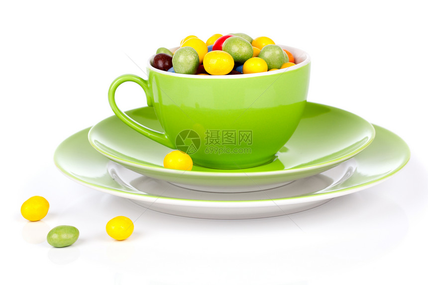 绿色杯子 有彩色糖果 白色背景图片