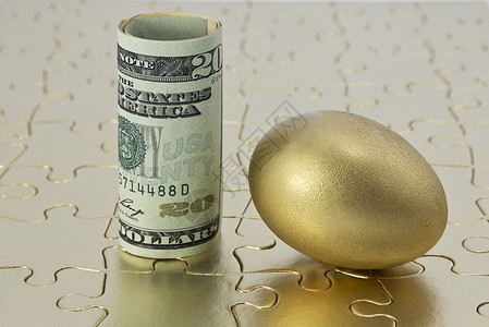 拼图上的金蛋和美元货币背景图片
