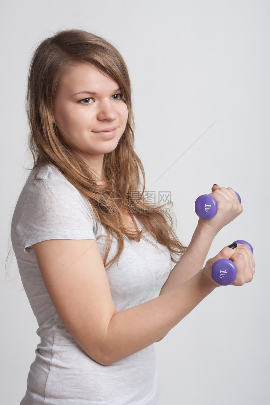 手拿哑铃的女孩健身房身体健康图片