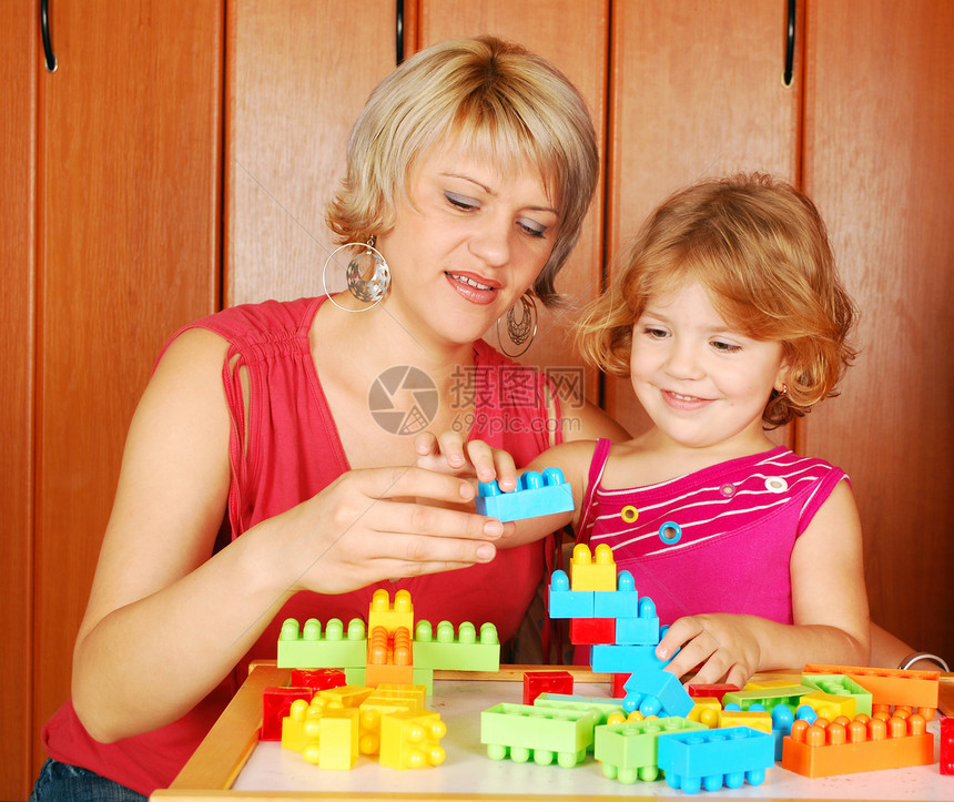 母亲和女儿在玩玩具砖游戏盒子父母建筑青年情怀女性乐趣女孩成人金发女郎图片