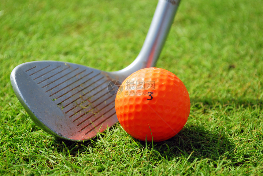 高尔夫球俱乐部和橙黄色高尔夫球图片