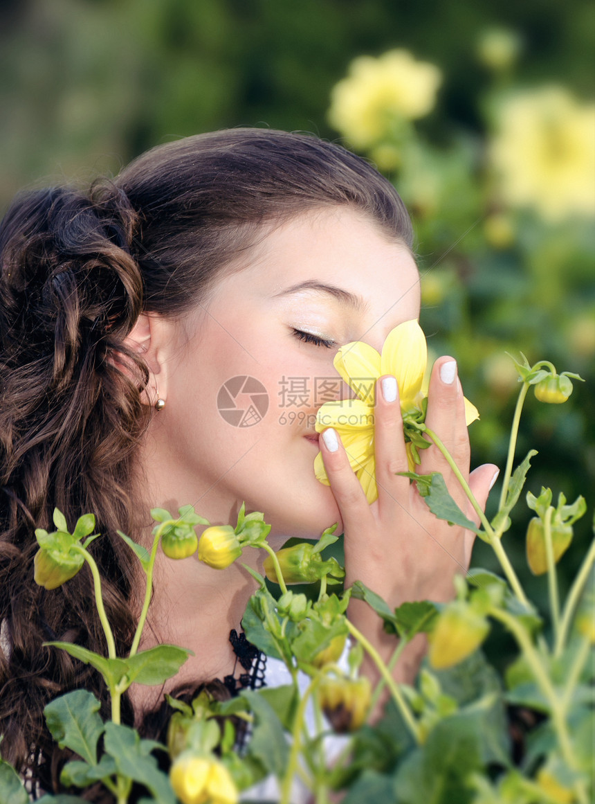 女孩闻着花朵的香味图片