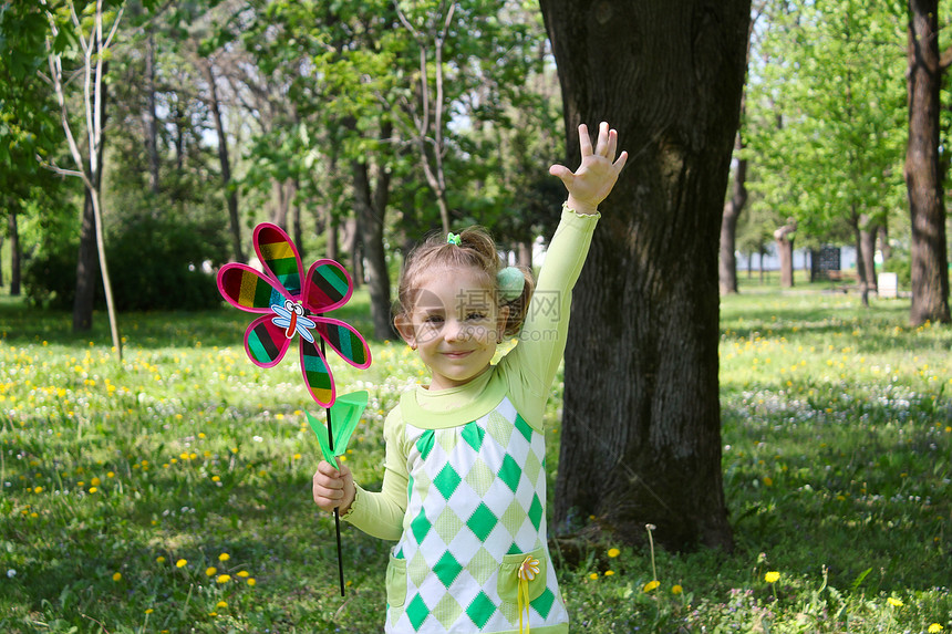 快乐的小女孩在公园里手举手图片