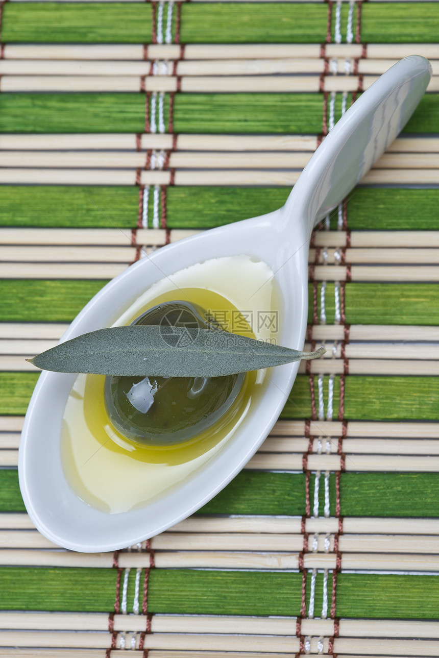 用中国勺子的橄榄蔬菜沙拉条纹飞碟内衬素食营养树叶水果小吃图片