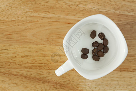 木本底咖啡杯中的咖啡豆宏观芳香咖啡工作室木头美食香气黑色奢华饮料背景图片
