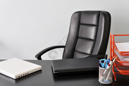 配有两台膝上型电脑的服务台椅子房子办公室笔记本白色皮革扶手椅桌子黑色工作背景图片