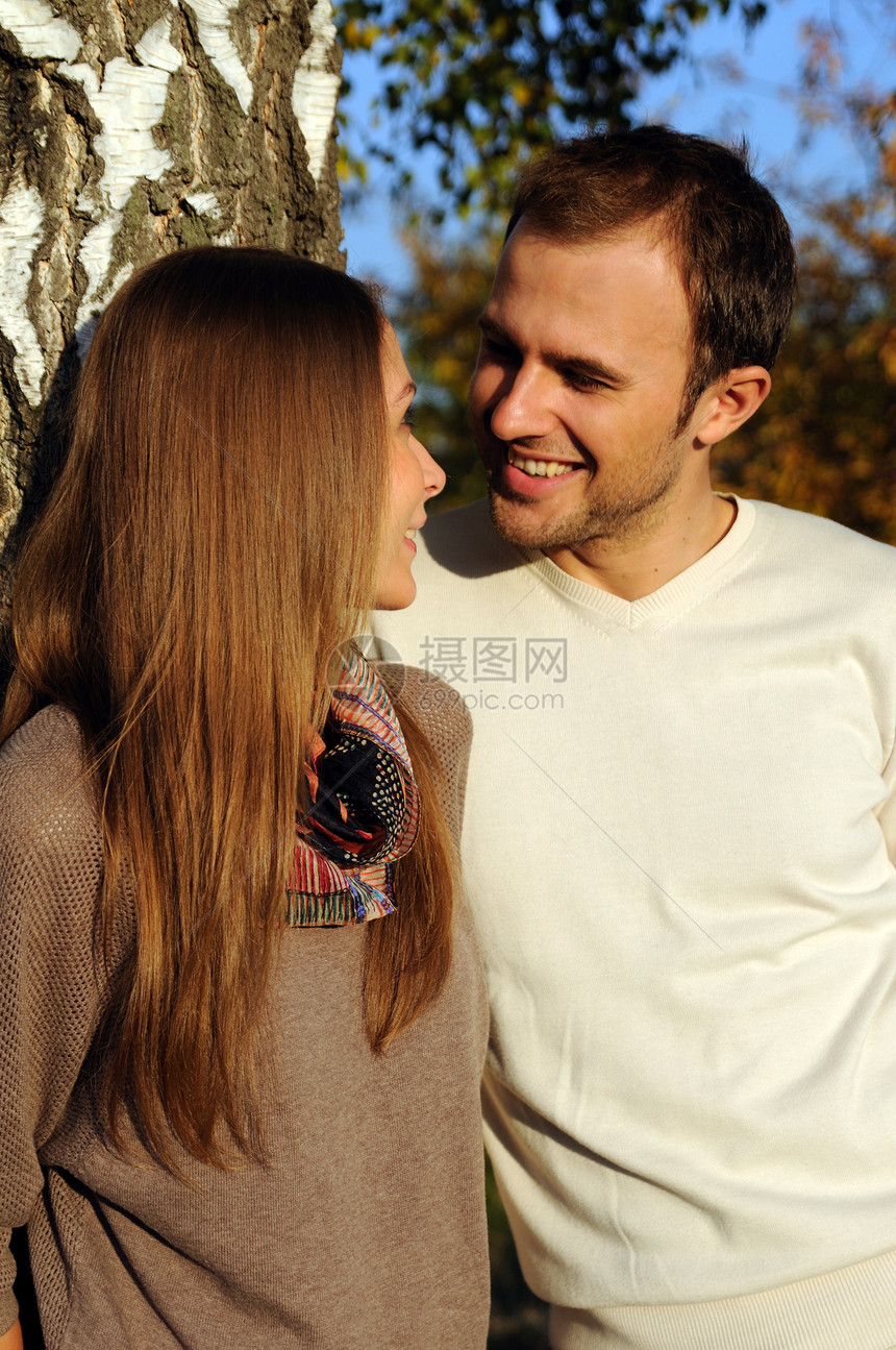 秋天一棵树下的年轻夫妇拥抱合伙闲暇喜悦夫妻黄色微笑公园休息图片