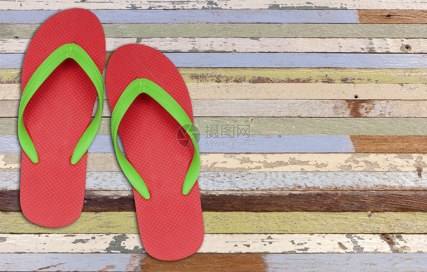 旧油漆木材上的红色和绿色的翻滚拖鞋图片