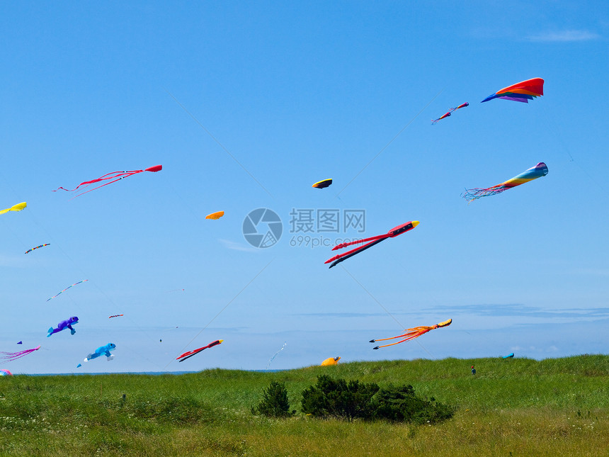 在明亮的蓝天空中飞来飞去条纹闲暇自由晴天蓝色游戏乐趣娱乐节日海滩图片