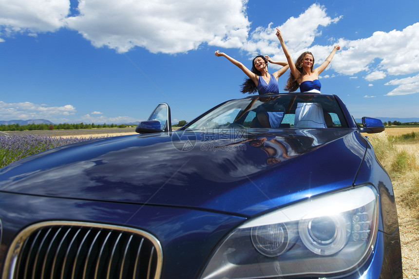 妇女在汽车中跳舞假期团队微笑喜悦男人友谊成人蓝色玻璃天空图片
