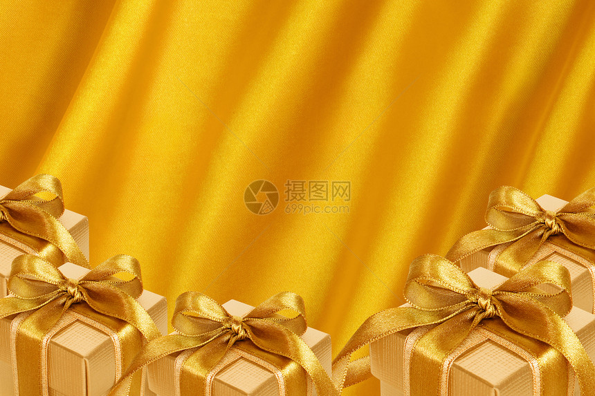 金沙子背景的黄金礼品盒金子季节织物热情窗帘奢华床单纺织品折叠衣服图片